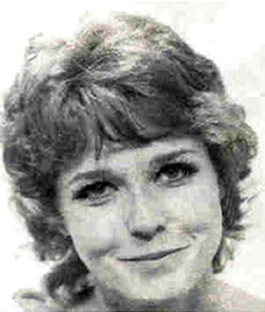 A picture of Kathy Harmon, smiling, with short hair and her head tilted to one side.